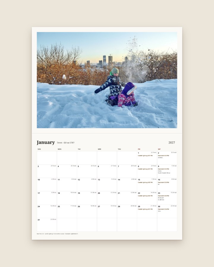 January page with one full-width photo of children playing in the snow above the month grid